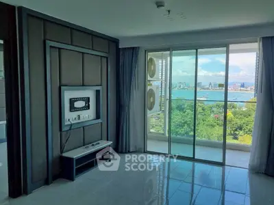 Spacious living room with stunning city and water view from large balcony.