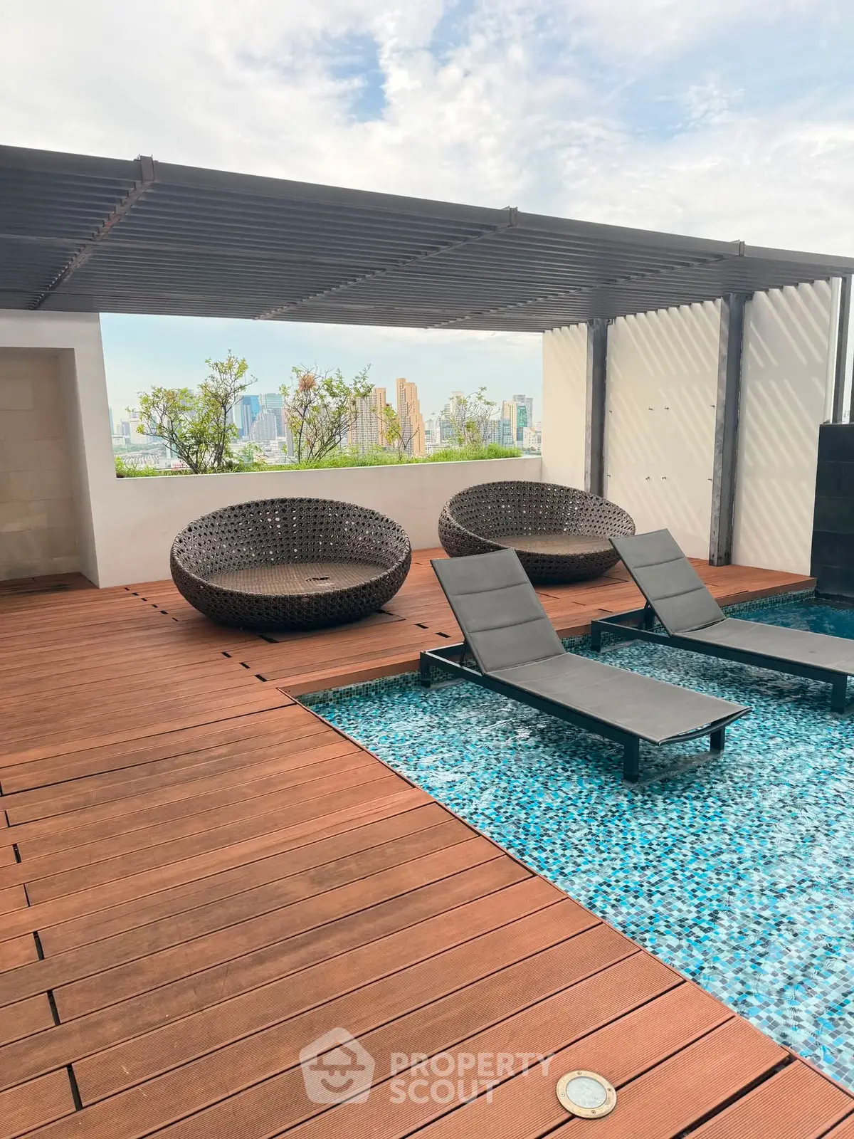 Luxurious rooftop pool with city skyline view and stylish lounge chairs.