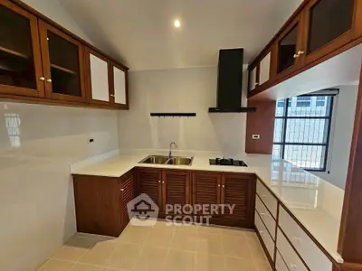 Modern kitchen with wooden cabinets and sleek countertops in a bright space.