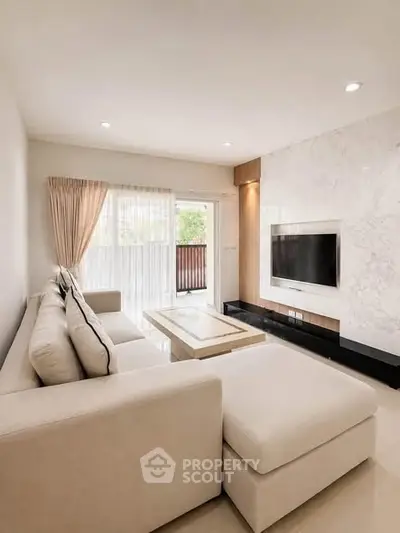 Elegant living room with modern decor and large windows leading to a balcony.