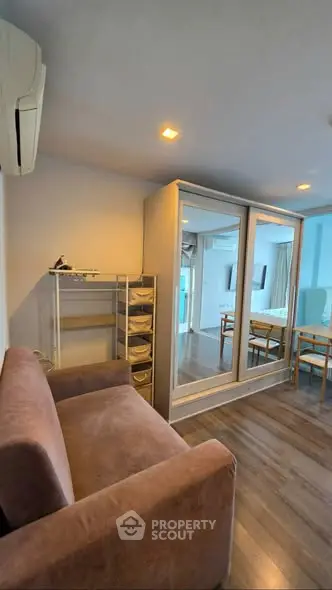 Modern living room with mirrored wardrobe and cozy sofa in a stylish apartment.