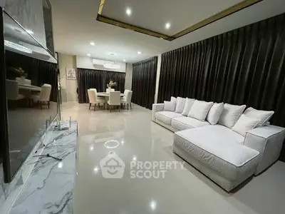 Luxurious modern living room with elegant dining area and plush white sofa, perfect for stylish entertaining.