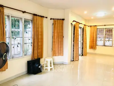 Spacious living room with large windows and elegant curtains