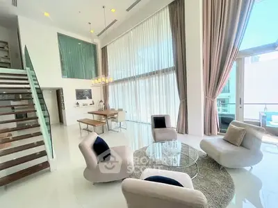 Luxurious modern living room with high ceilings and elegant decor in a spacious apartment.