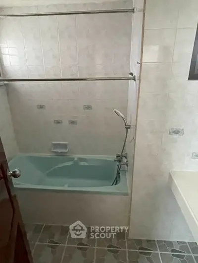 Cozy bathroom with bathtub and tiled walls, perfect for relaxation.
