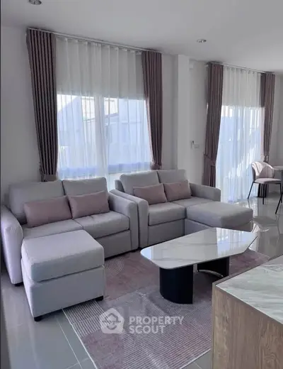 Modern living room with stylish gray sofas and elegant curtains, perfect for relaxation.