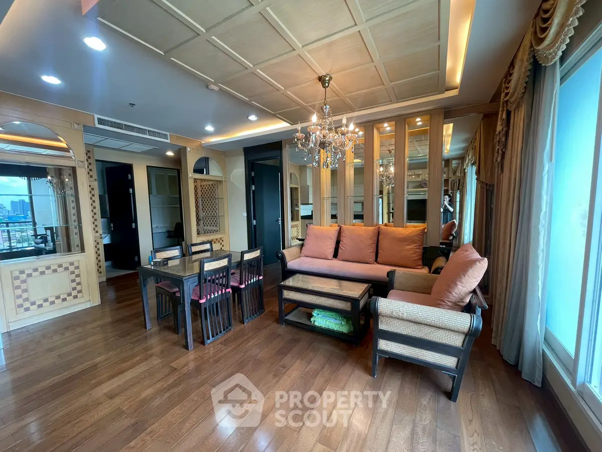 Luxurious living room with elegant chandelier and hardwood floors in high-rise apartment
