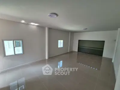 Spacious empty room with glossy tiled floor and large window, ideal for customization.