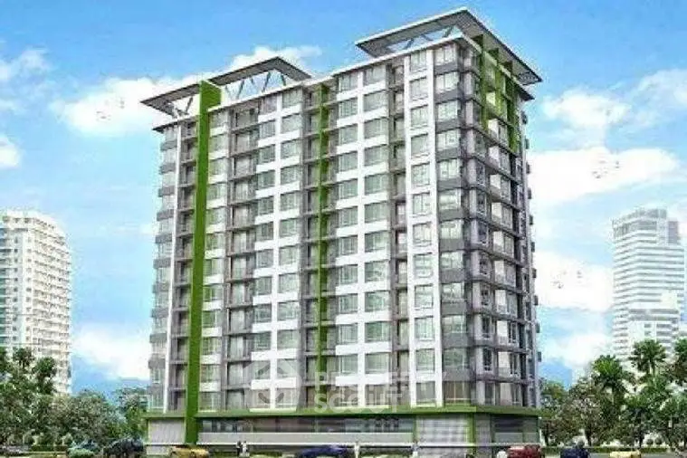 Modern high-rise building with green accents and urban skyline view.
