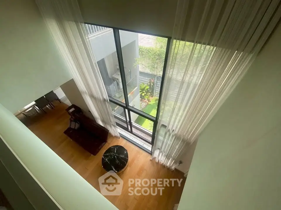 Stunning high-ceiling living room with floor-to-ceiling windows and elegant decor