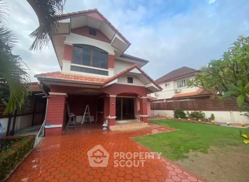 Charming two-story house with red brick facade and spacious front yard