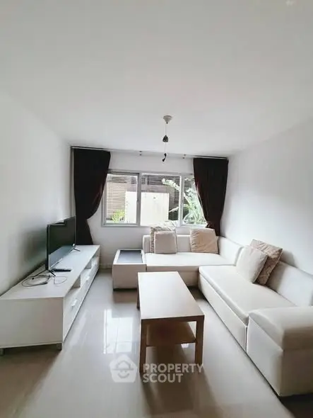 Bright and cozy living room with modern white furniture and natural light.