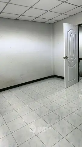 Spacious empty room with tiled floor and open door