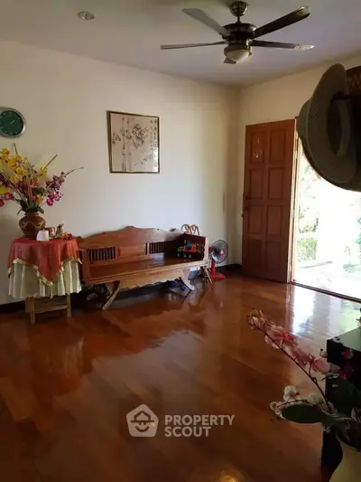 Charming living room with wooden flooring, elegant decor, and natural light, perfect for cozy gatherings.