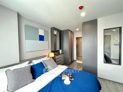 Modern bedroom with blue accents and stylish decor in a contemporary apartment.