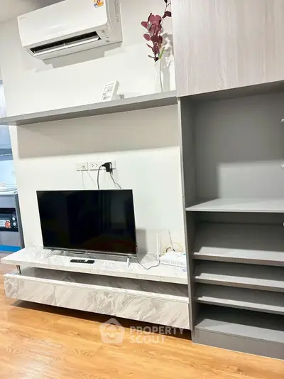 Modern living room with sleek TV unit and air conditioning, perfect for cozy entertainment.