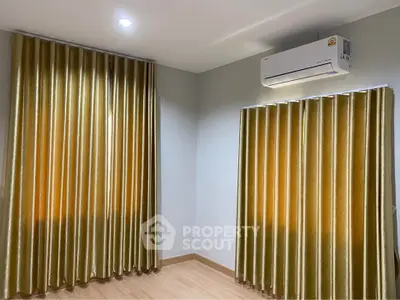 Spacious room with elegant curtains and modern air conditioning unit, perfect for comfortable living.