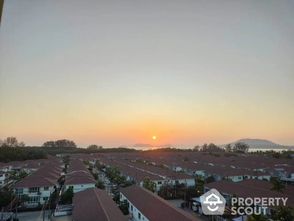 Stunning sunset view over suburban neighborhood with rows of charming houses and distant mountains.