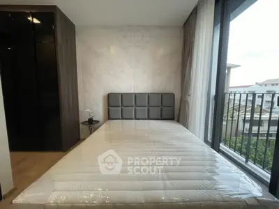 Modern bedroom with sleek design and balcony view in a luxury apartment.