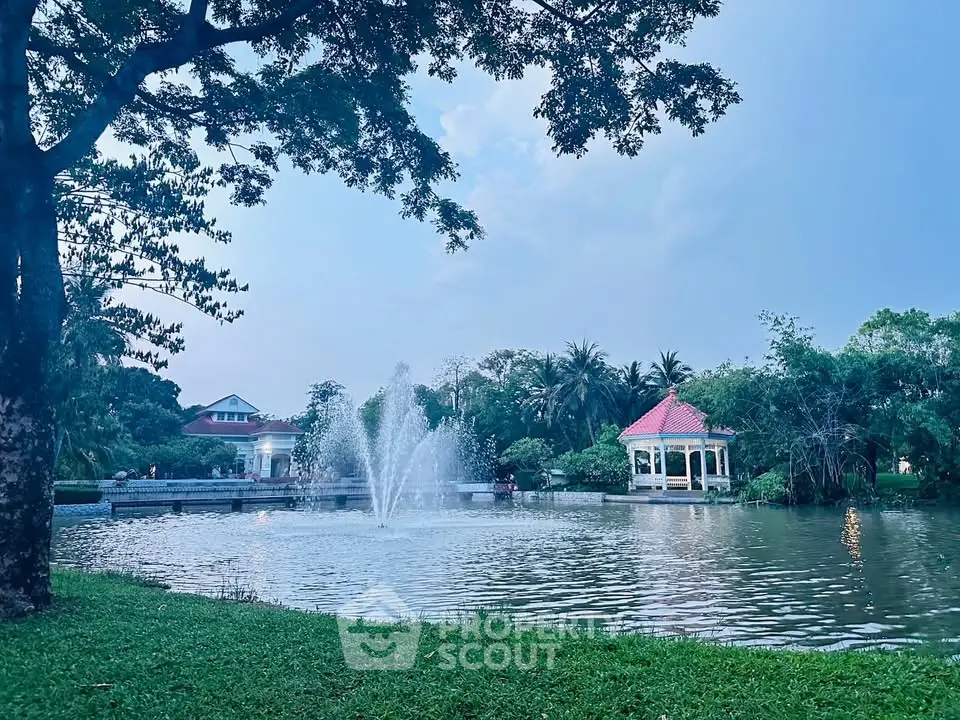 Serene garden view with a picturesque pond and charming gazebo, perfect for relaxation.