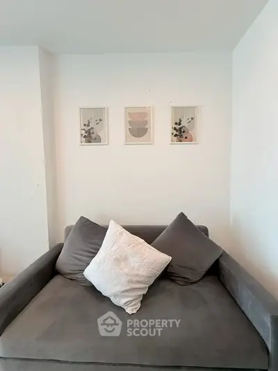 Cozy living room with modern gray sofa and stylish wall art, perfect for relaxation.