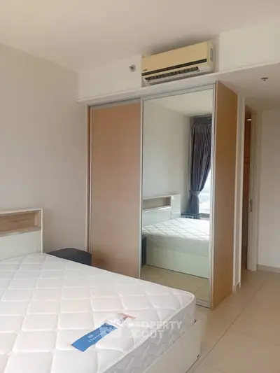 Modern bedroom with mirrored closet and air conditioning in a bright apartment.