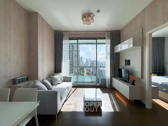Modern living room with city view, elegant decor, and natural light in a high-rise apartment.