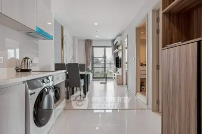 Modern apartment interior with open kitchen and living area, featuring sleek appliances and stylish decor.