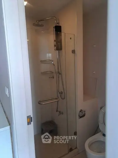 Compact bathroom with modern shower and toilet in a cozy apartment.