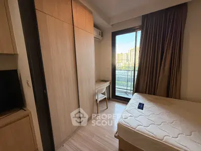 Cozy bedroom with balcony view and modern furnishings in urban apartment