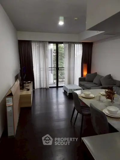 Modern living room with sleek furniture and balcony view in a stylish apartment.
