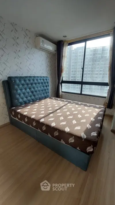 Spacious bedroom with large window and modern decor in urban apartment