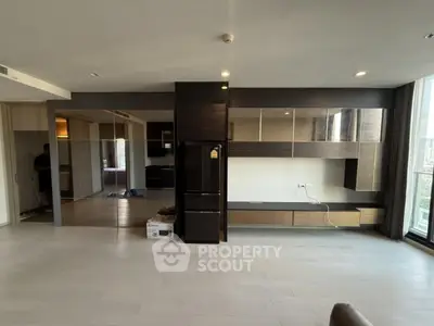 Spacious modern living room with sleek built-in storage and large windows.