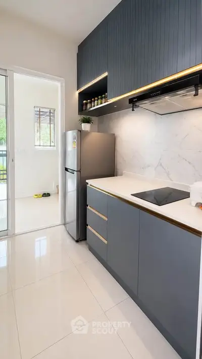 Modern kitchen with sleek cabinetry and built-in appliances, featuring a minimalist design and ample natural light.