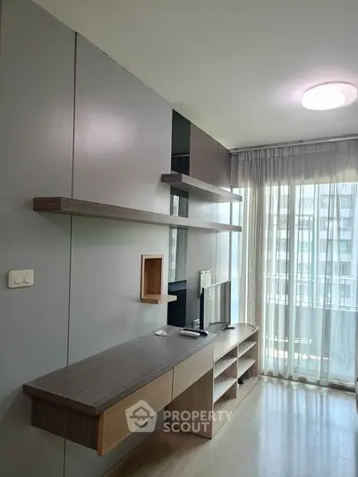 Modern living room with sleek built-in shelves and large window offering natural light.