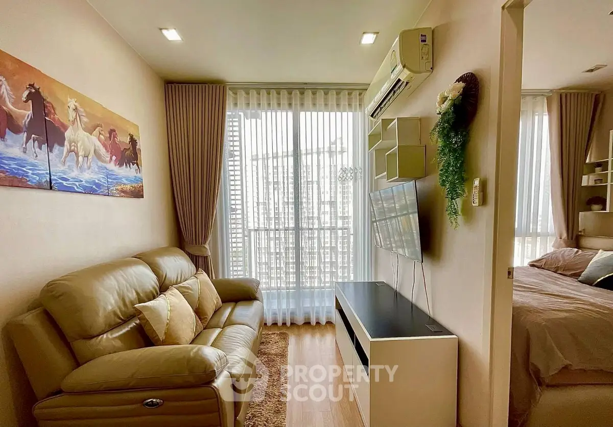 Cozy living room with leather sofa, wall art, and large window in modern apartment.
