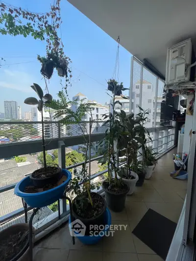 Spacious balcony with potted plants and city view, perfect for relaxation.