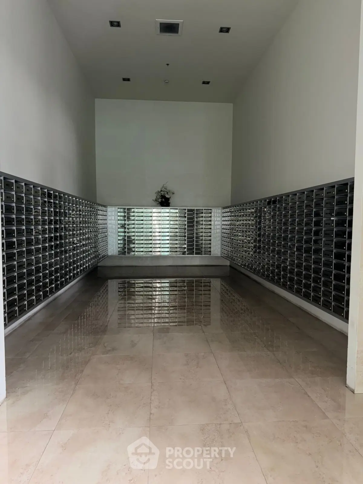 Spacious modern building entrance with sleek mailboxes and polished floors.