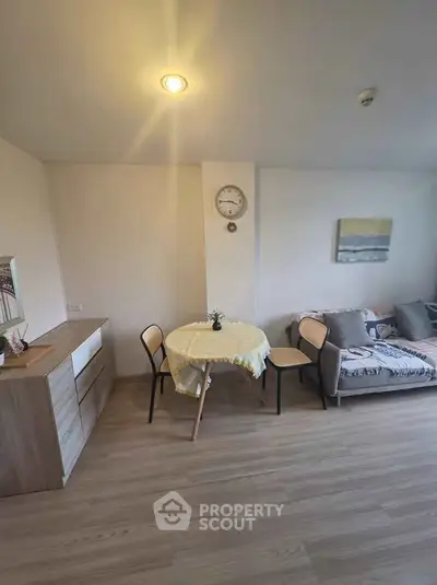 Cozy living room with modern decor and dining area in a stylish apartment.