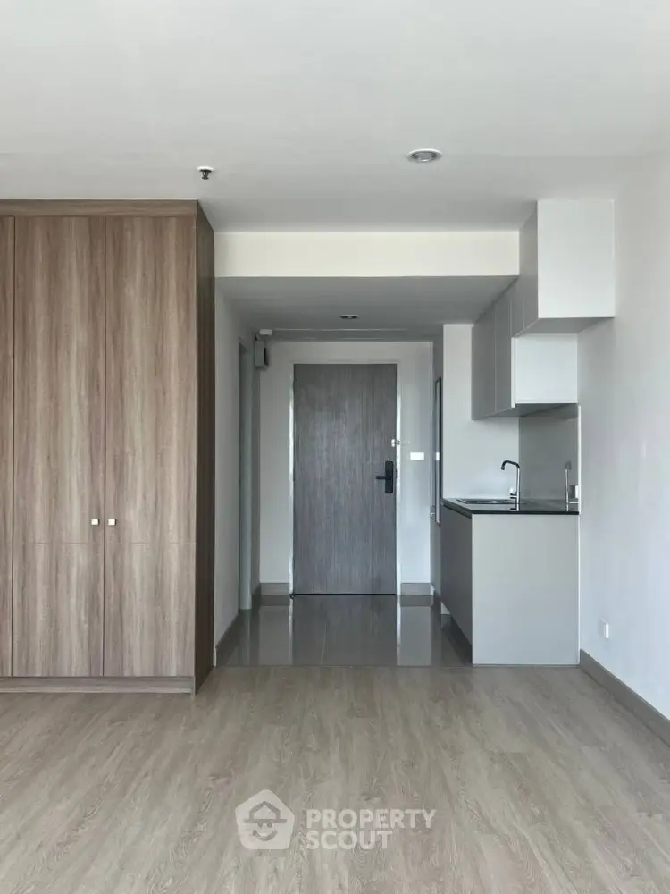 Modern apartment interior with sleek kitchen and wooden flooring