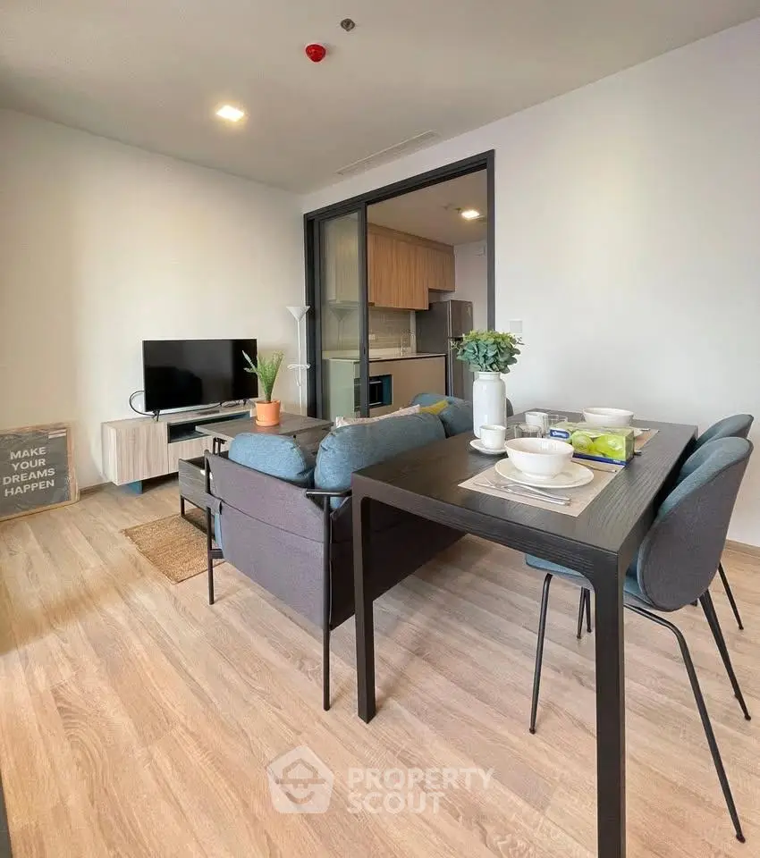 Modern living room with dining area and open kitchen in stylish apartment.
