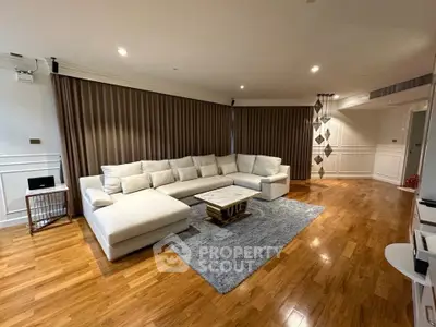 Spacious living room with elegant wooden flooring and modern sectional sofa