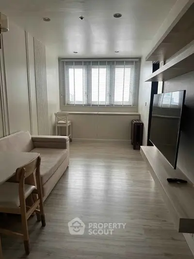 Modern living room with sleek design, featuring a wall-mounted TV and cozy seating area.