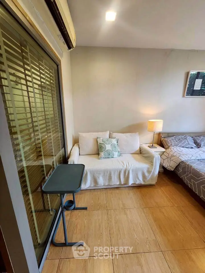 Cozy living room with sofa, bed, and side table in modern apartment.