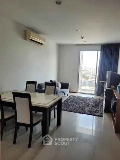 Modern living room with dining area and city view balcony in a stylish apartment.