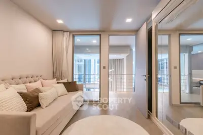Modern living room with elegant decor and large windows offering natural light.