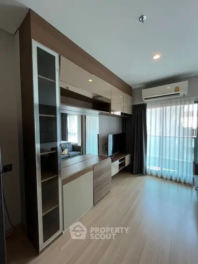 Modern living room with sleek wooden furniture and large window for natural light.