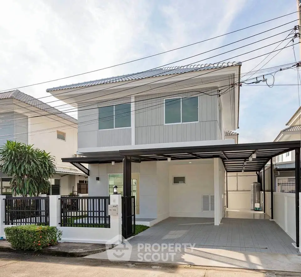 Modern two-story house with carport and landscaped front yard in a suburban neighborhood.