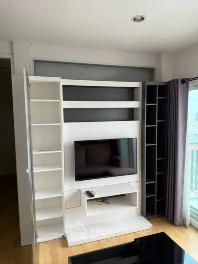 Modern living room with sleek TV unit and city view balcony