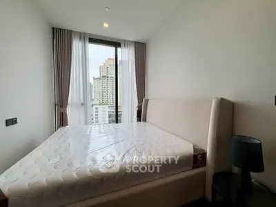 Modern bedroom with large window and city view, featuring a stylish bed and elegant decor.